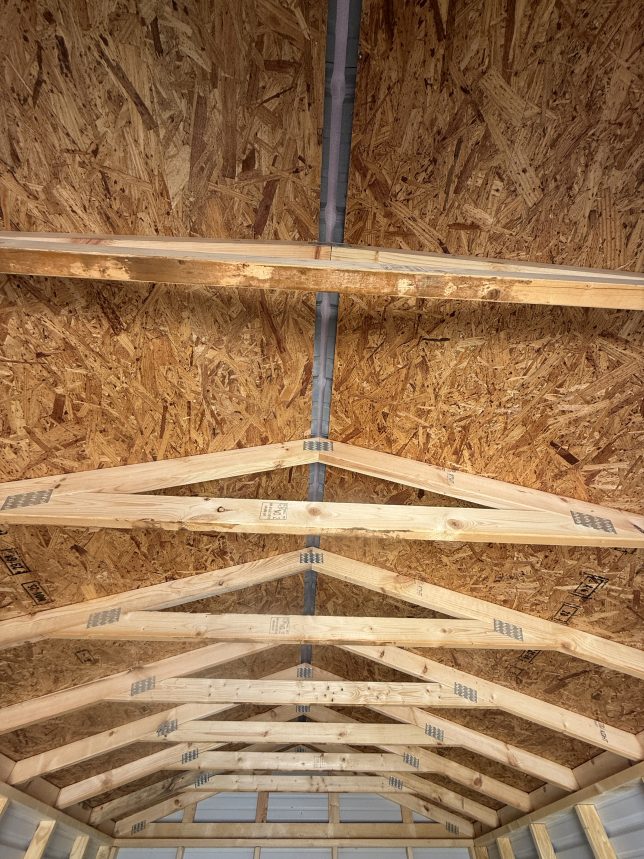 Ridge cap vent opening inside metal shed for airflow and moisture control