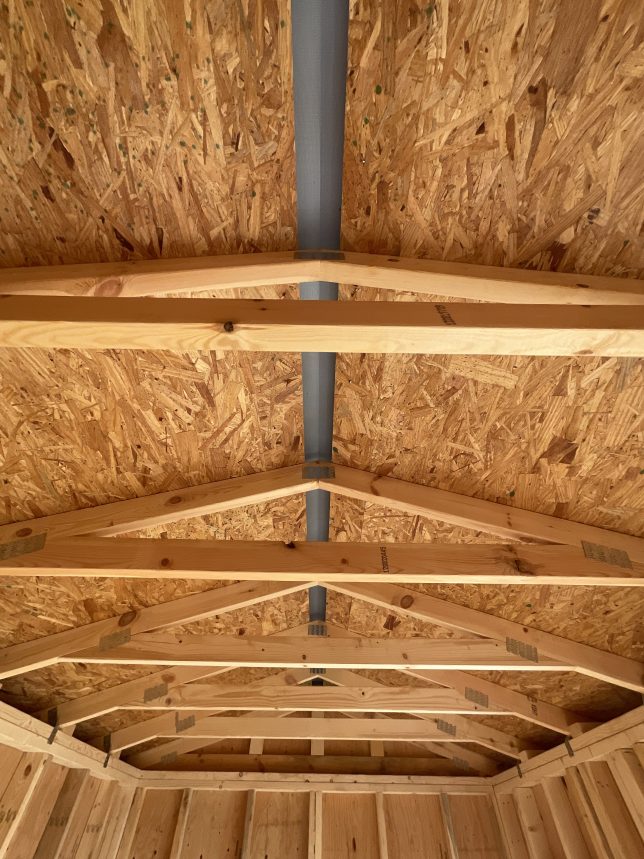 Interior roof trusses and ridge cap vent inside portable shed in Covington LA